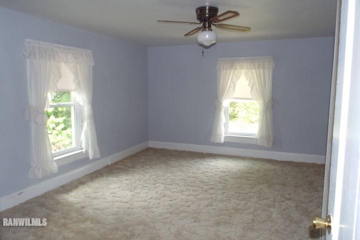 3492 South Eby's Mill Road Elizabeth, IL 61028 - Photo 11 of 20 an empty room with a window and a fan