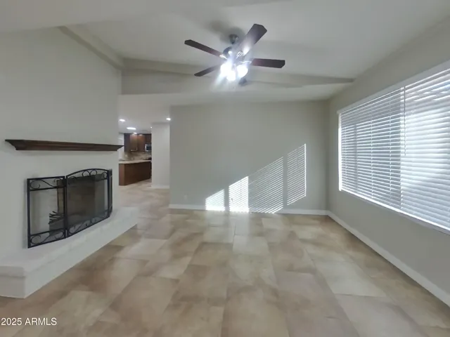 a view of an empty room with a fireplace and a window