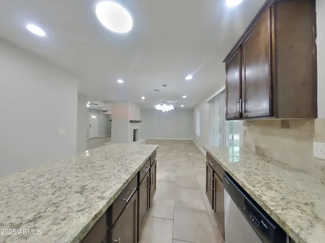 a view of a kitchen island a sink a refrigerator and wooden floor
