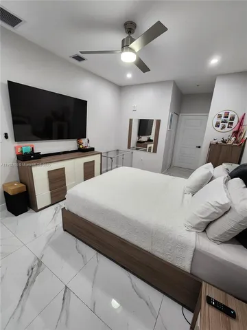 a large bedroom with a bed and a flat screen tv