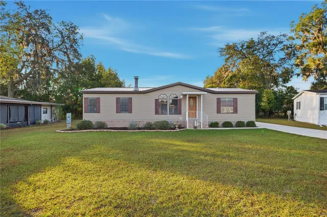 a view of a yard in front of a house with a large tree