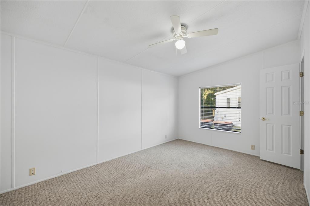 6524 Southeast 110th Lane Belleview, FL 34420 - Photo 16 of 32 an empty room with chandelier fan and windows