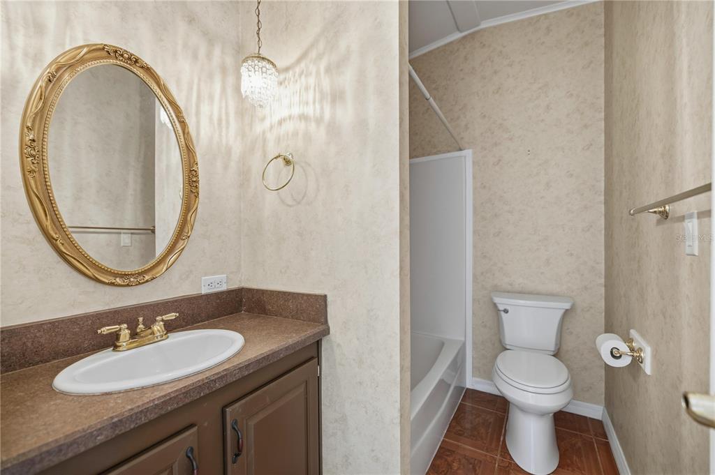 6524 Southeast 110th Lane Belleview, FL 34420 - Photo 18 of 32 a bathroom with a granite countertop toilet a sink and a mirror