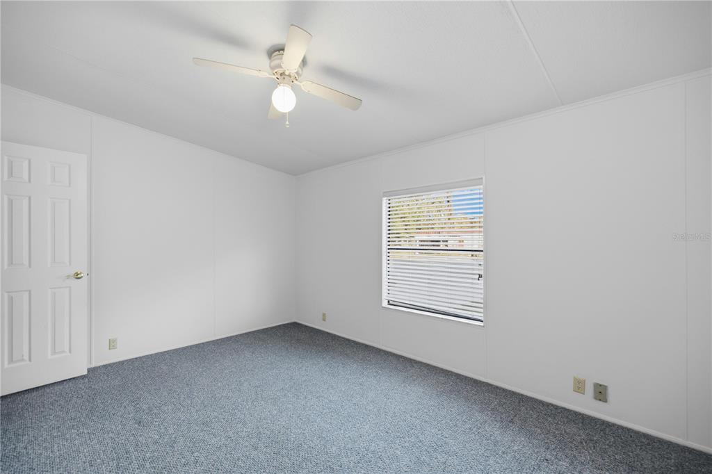 6524 Southeast 110th Lane Belleview, FL 34420 - Photo 20 of 32 an empty room with a window and a ceiling fan