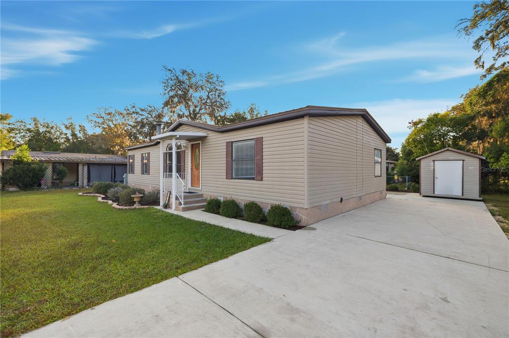 6524 Southeast 110th Lane Belleview, FL 34420 - Photo 32 of 32 a front view of a house with a garden and yard