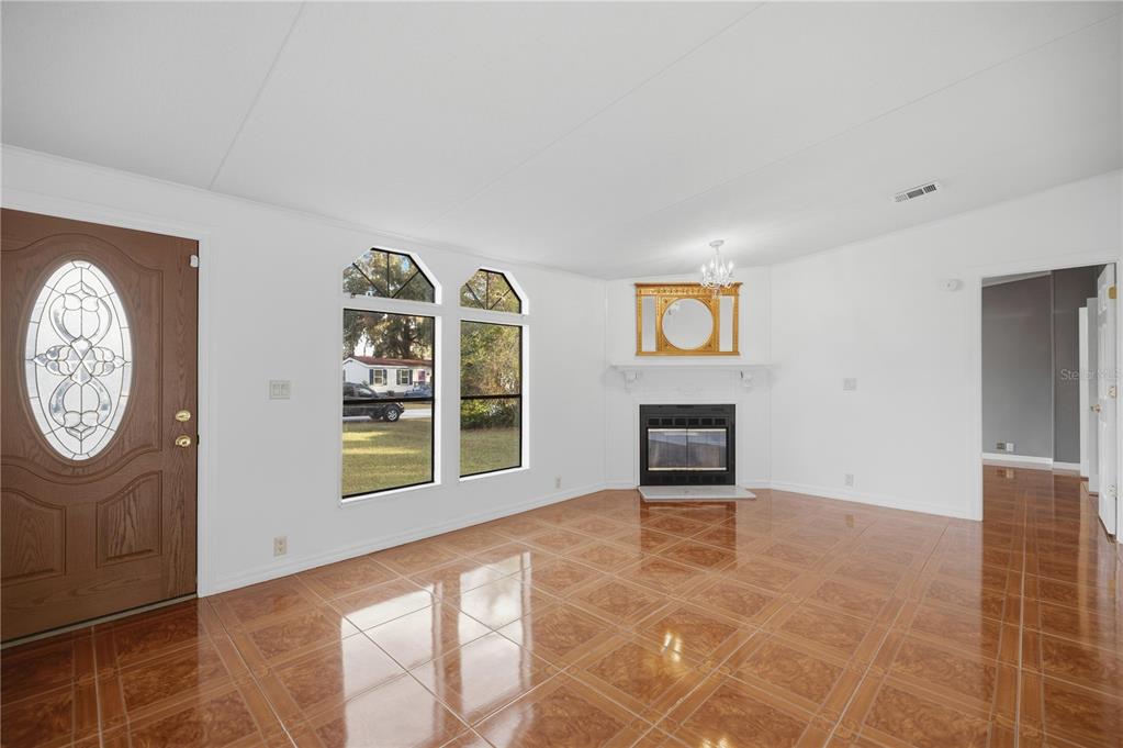 6524 Southeast 110th Lane Belleview, FL 34420 - Photo 5 of 32 a view of an empty room with a window and a fireplace