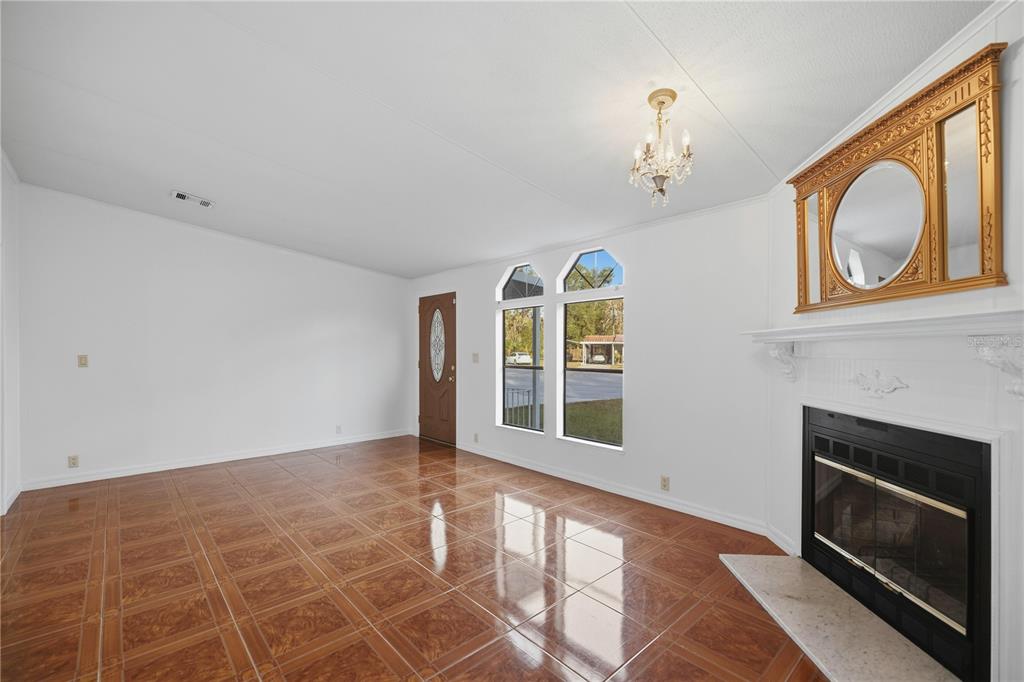 6524 Southeast 110th Lane Belleview, FL 34420 - Photo 6 of 32 a view of an empty room with a fireplace and a window