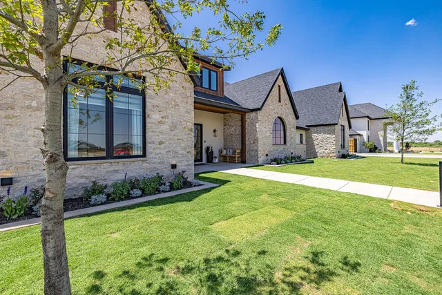 a large kitchen with a large window a sink stainless steel appliances and cabinets