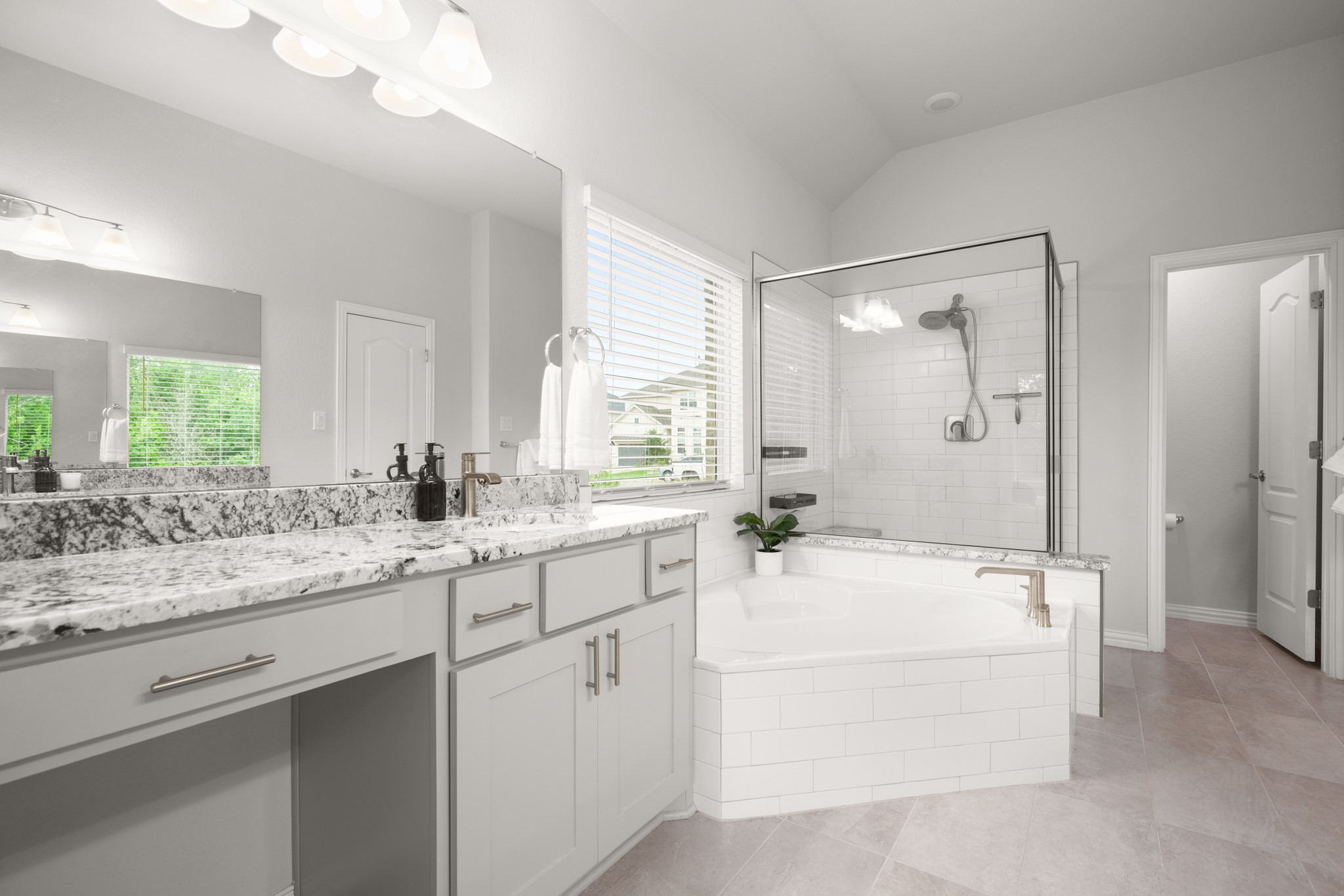 6708 Avila Way Pflugerville, TX 78660 - Photo 17 of 36 a bathroom with a sink double vanity mirror and a bathtub