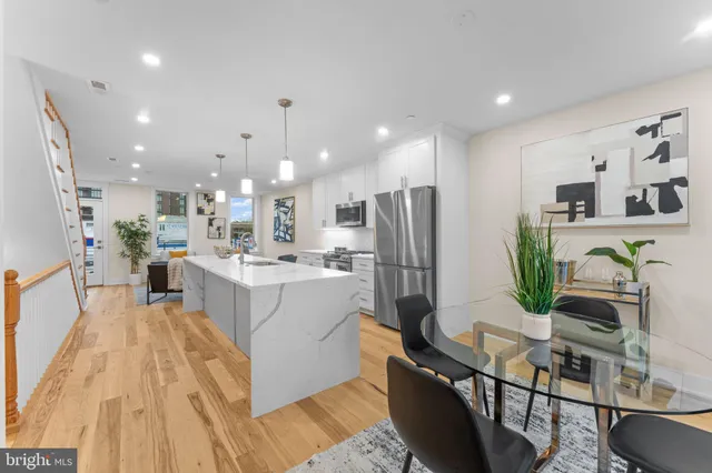 a living room with stainless steel appliances kitchen island granite countertop furniture wooden floor and a view of kitchen