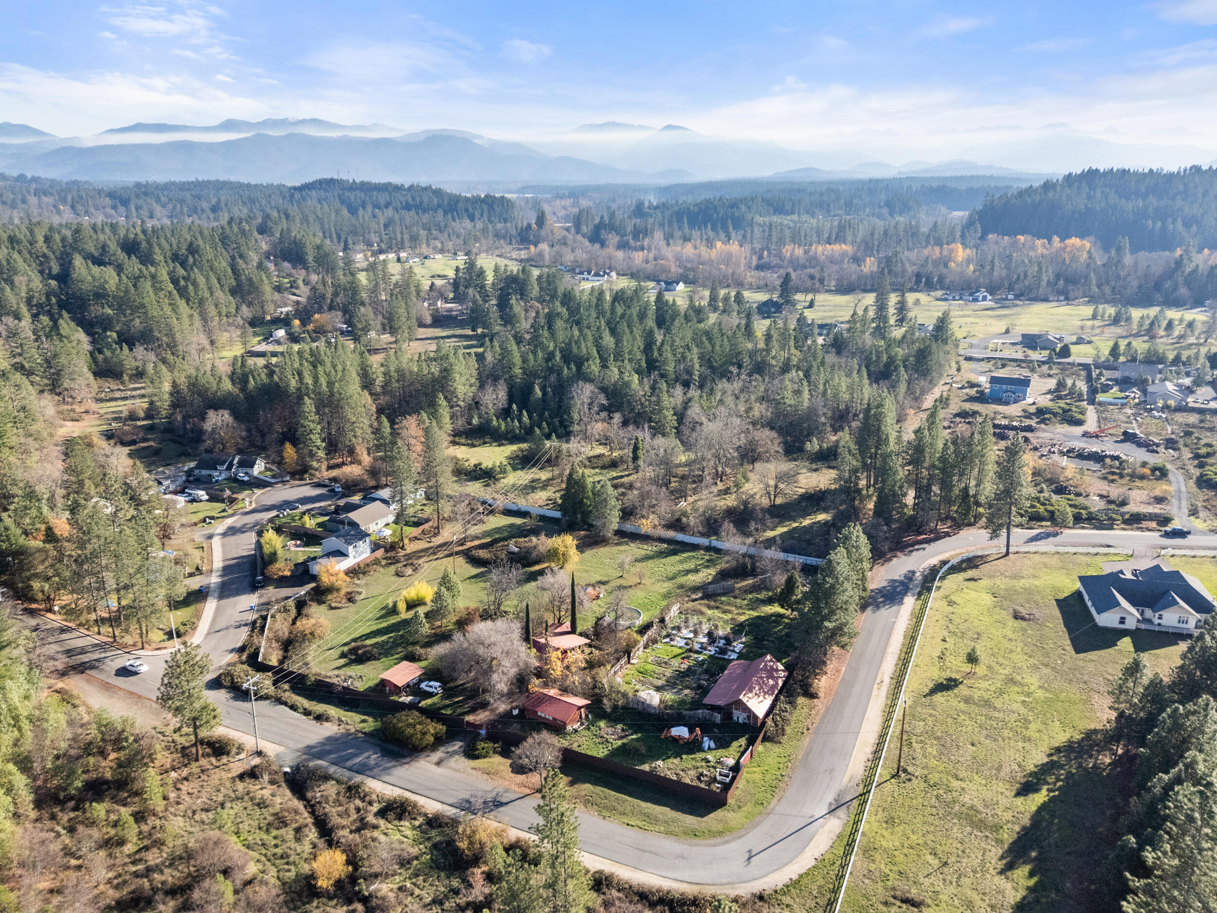 681 Daisy Hill Road Cave Junction, OR 97523 - Photo 9 of 26 an aerial view of a house with a swimming pool a yard and mountain view in back