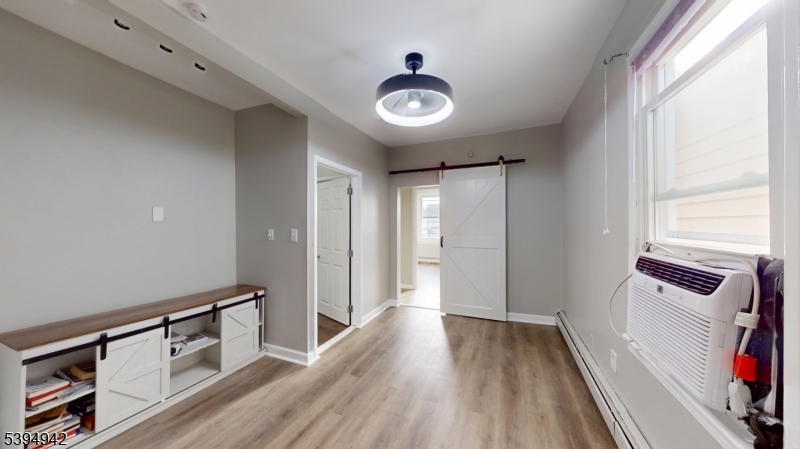 277 2nd Avenue West Newark, NJ 07107 - Photo 4 of 7 a view of a hallway to a livingroom with wooden floor and furniture
