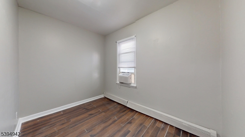 277 2nd Avenue West Newark, NJ 07107 - Photo 5 of 7 a view of an empty room with wooden floor and a window