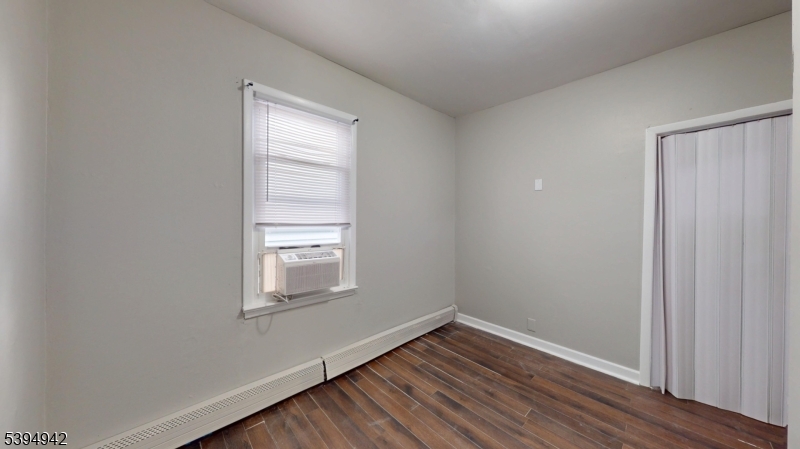 277 2nd Avenue West Newark, NJ 07107 - Photo 6 of 7 a view of an empty room with wooden floor and a window