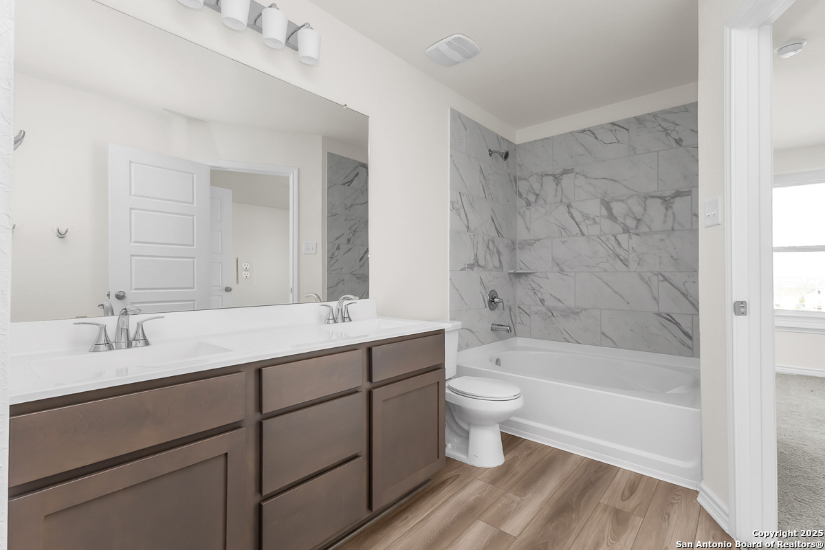 9402 Griffith Run Converse, TX 78109 - Photo 15 of 18 a bathroom with a bathtub shower sink vanity and toilet