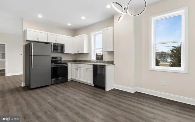 a kitchen with stainless steel appliances a refrigerator and a stove top oven