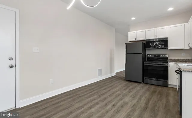a kitchen with a refrigerator and a stove top oven