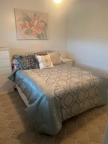 a bedroom with a bed and painting on the wall