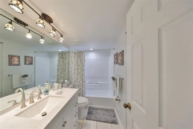 a bathroom with a double vanity sink a toilet and shower