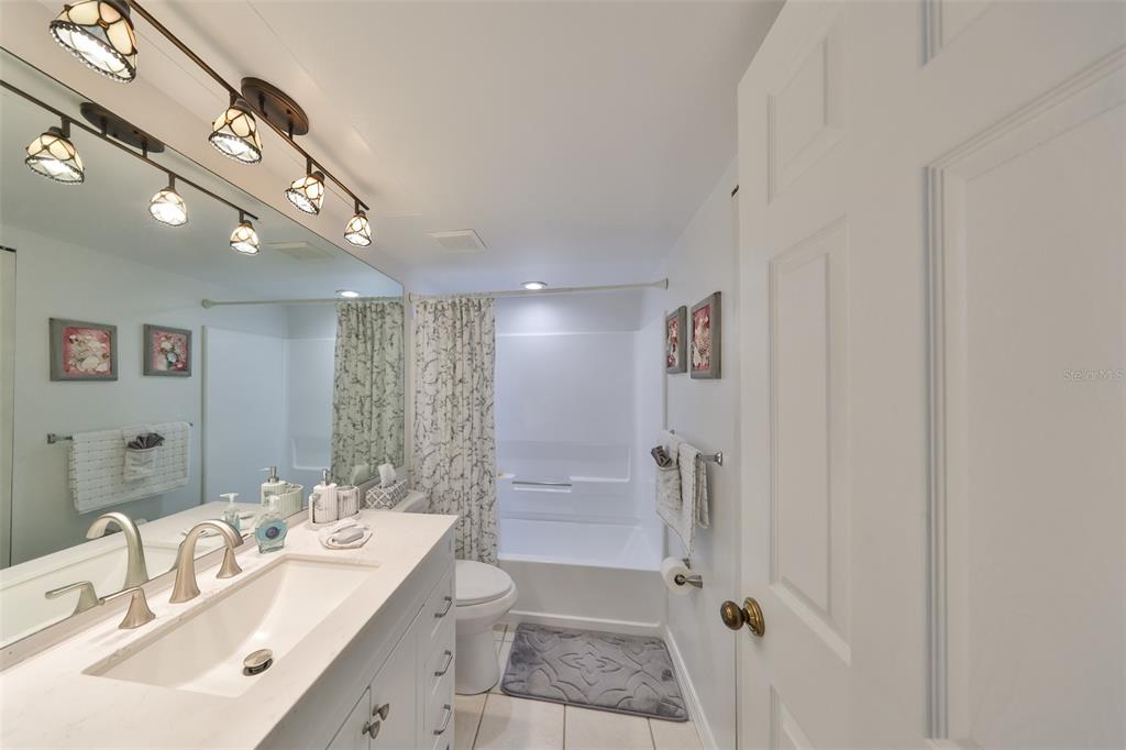 6123 113th Street, Unit 510 Seminole, FL 33772 - Photo 19 of 44 a bathroom with a double vanity sink a toilet and shower