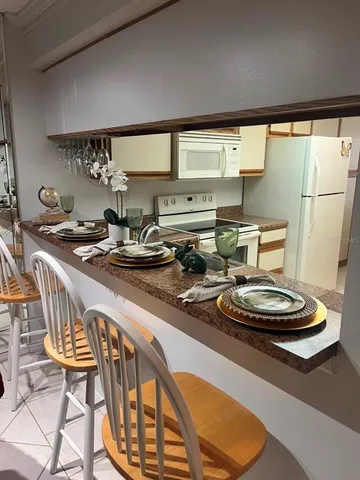 a kitchen with a table chairs stove and sink