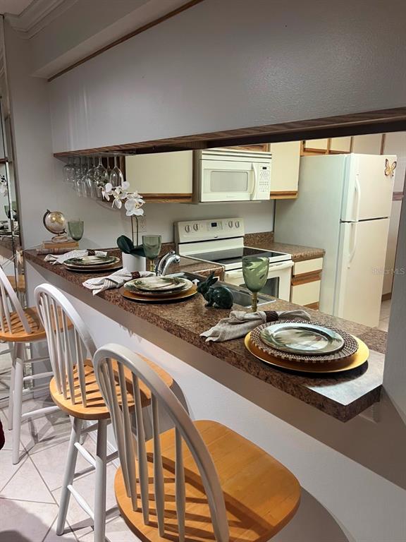 6123 113th Street, Unit 510 Seminole, FL 33772 - Photo 7 of 44 a kitchen with a table chairs stove and sink