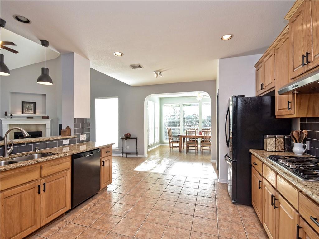 9216 Evening Primrose Path Austin, TX 78750 - Photo 13 of 30 a large kitchen with stainless steel appliances granite countertop a stove a sink a refrigerator and a refrigerator