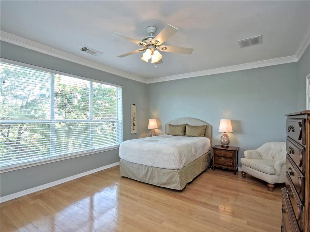 9216 Evening Primrose Path Austin, TX 78750 - Photo 18 of 30 a bedroom with a large bed and a chandelier