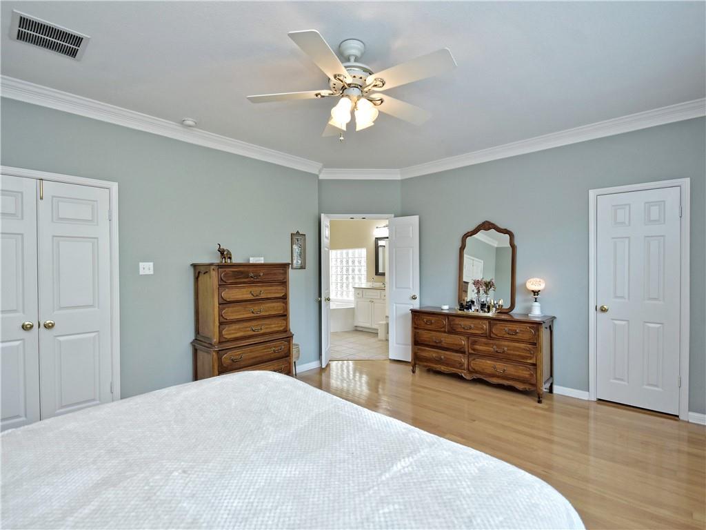 9216 Evening Primrose Path Austin, TX 78750 - Photo 19 of 30 a bedroom with a bed and a chandelier