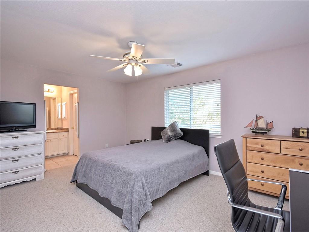 9216 Evening Primrose Path Austin, TX 78750 - Photo 22 of 30 a bedroom with a bed and a chandelier