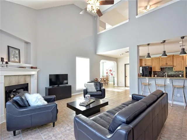 a living room with furniture a fireplace and a flat screen tv