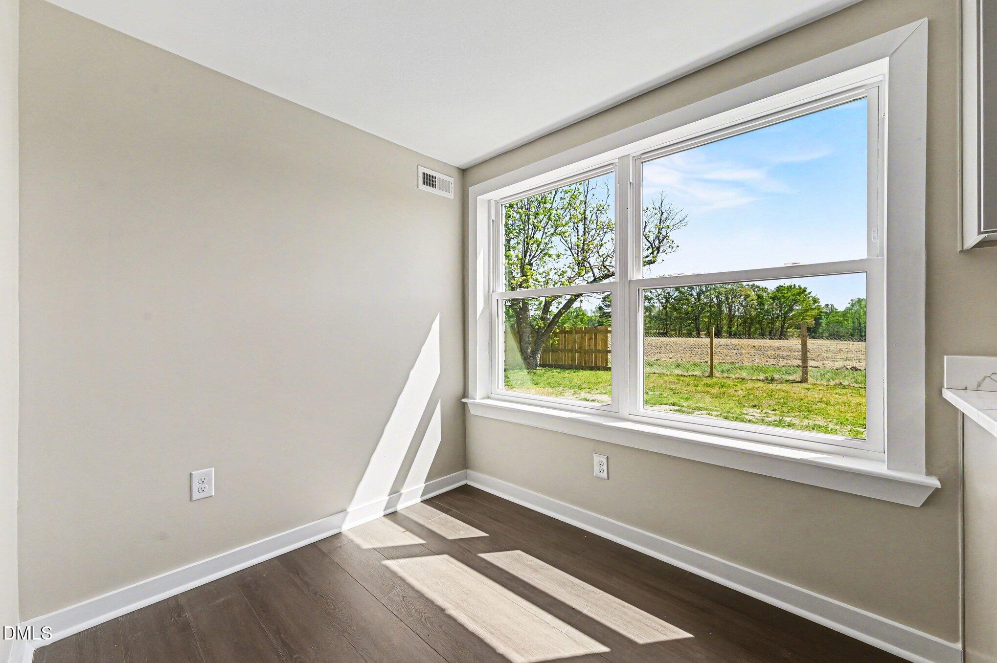 1325 Charlie Carr Road Roxboro, NC 27574 - Photo 16 of 31 an empty room with wooden floor and windows