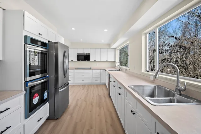 a kitchen with stainless steel appliances granite countertop a refrigerator and a sink