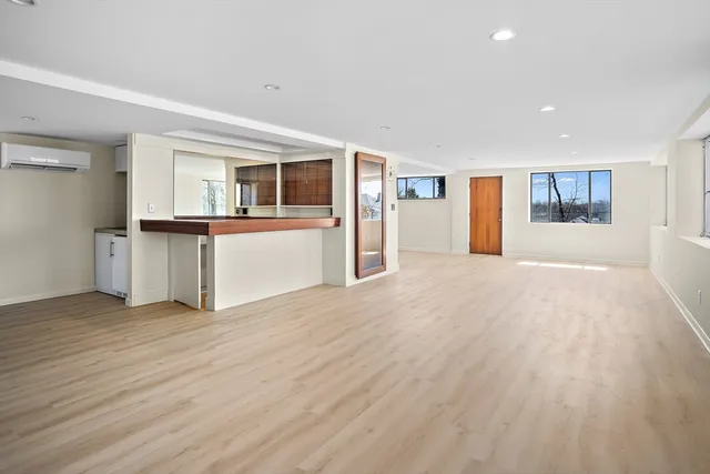 a view of a kitchen with wooden floor and electronic appliances