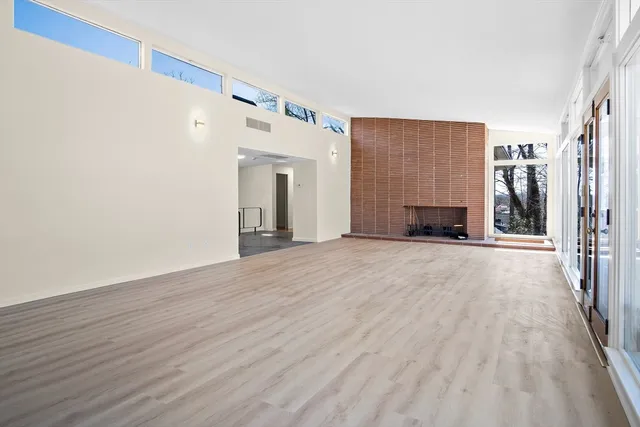a view of empty room with wooden floor and fireplace