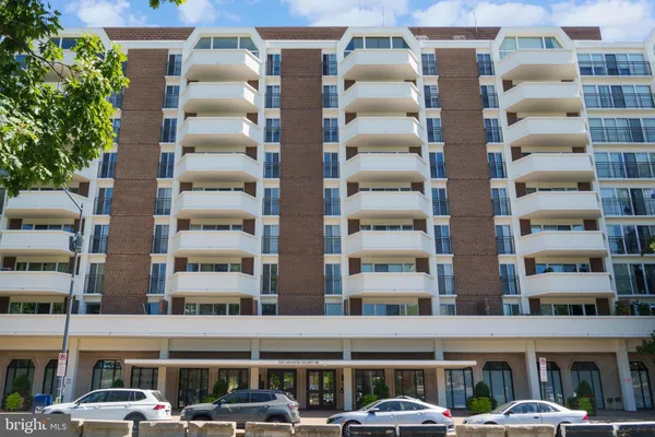 a front view of multi story residential apartment building with a yard