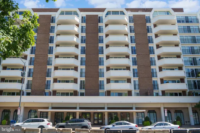a front view of multi story residential apartment building with a yard