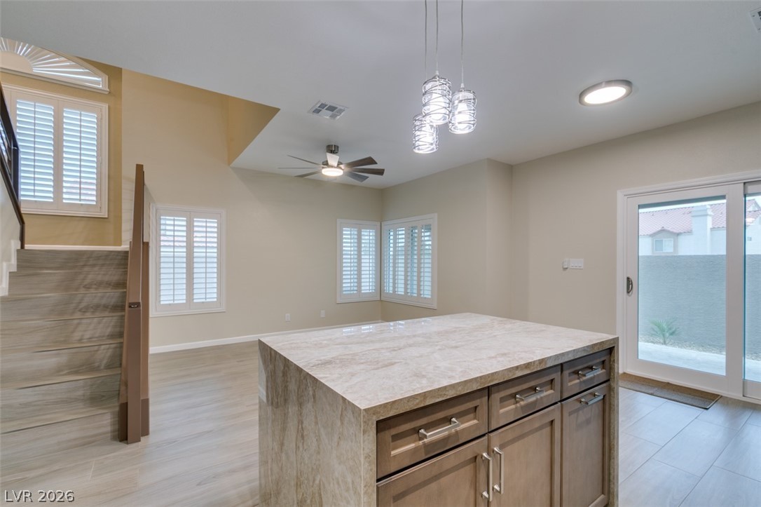 540 Sutters Mill Road Henderson, NV 89014 - Photo 32 of 46 This living area features a modern kitchen island, stylish staircase, and abundant natural light.