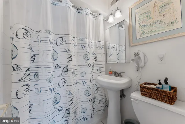 a bathroom with a sink mirror and a toilet