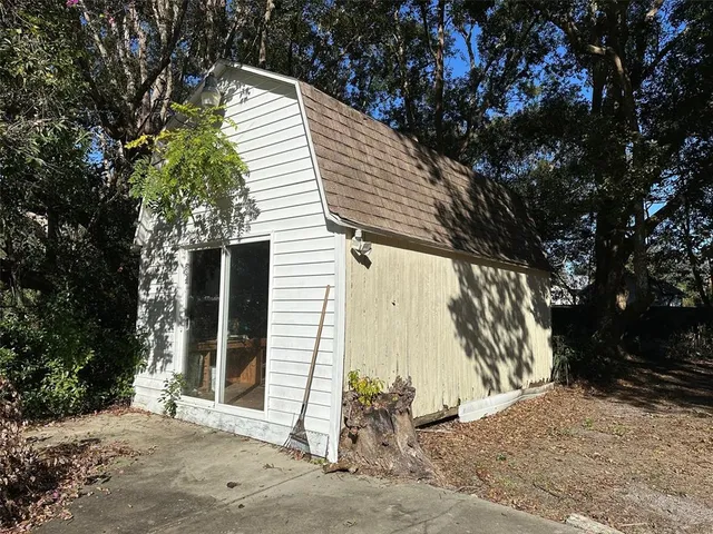 a view of a wooden house with a large tree