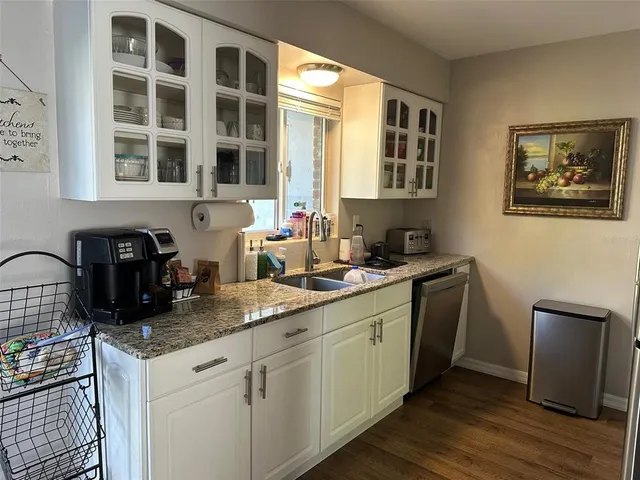 a kitchen with granite countertop a sink and a stove top oven