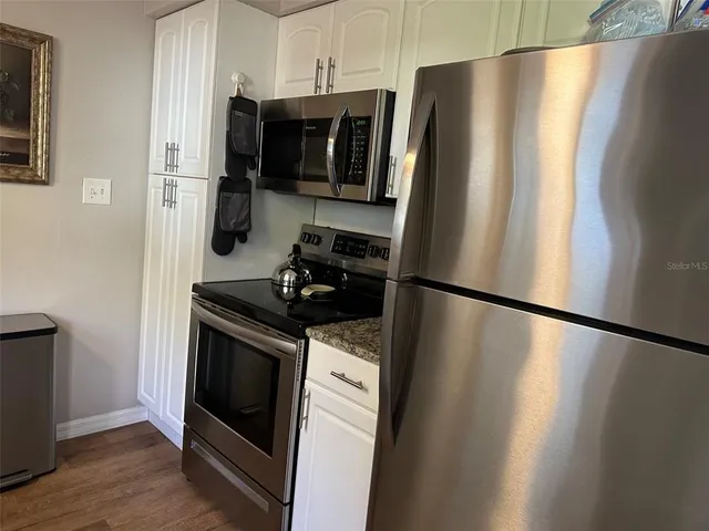 a kitchen with stainless steel appliances a refrigerator stove and microwave