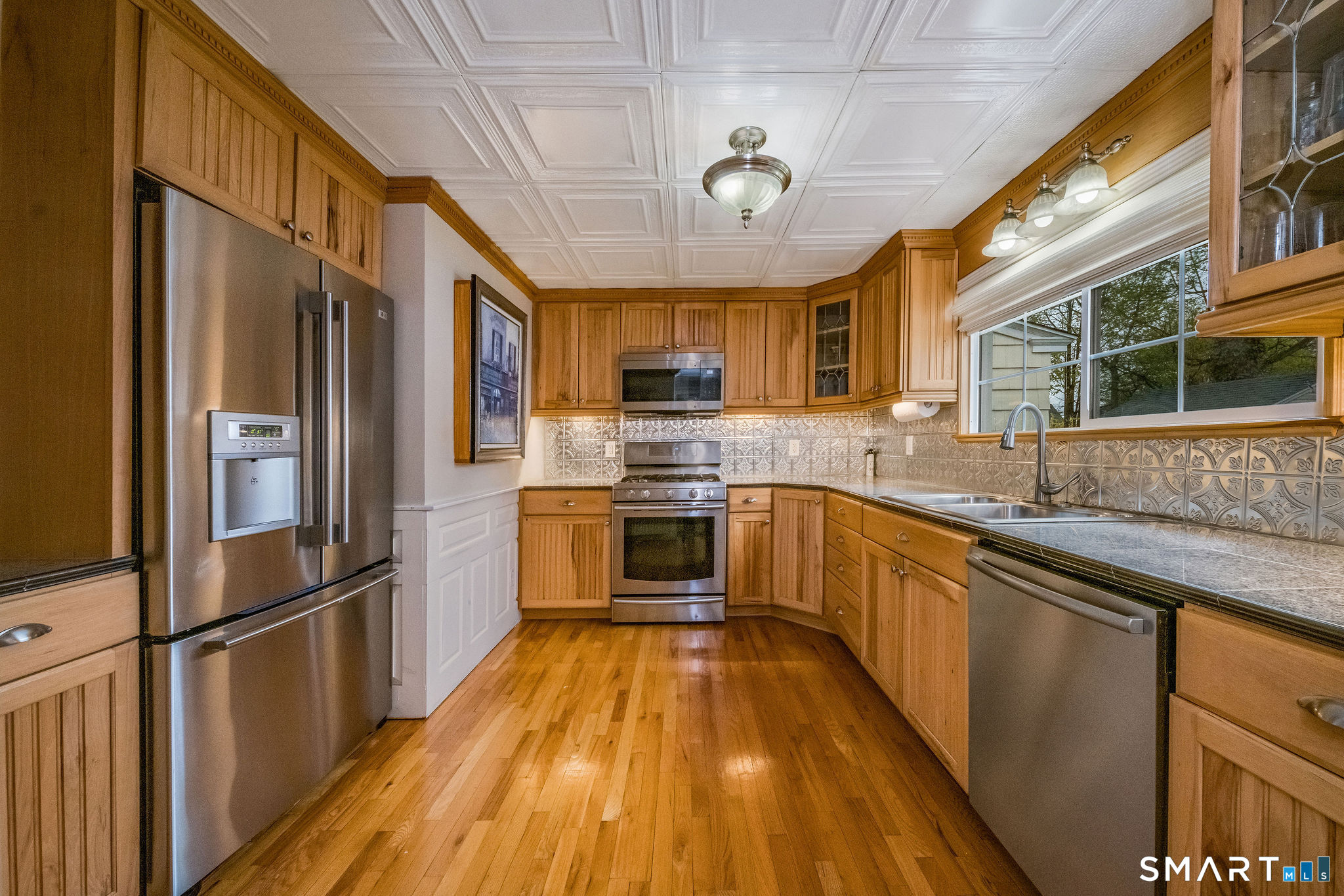 6 Cedar Island Avenue Clinton, CT 06413 - Photo 7 of 36 a large kitchen with stainless steel appliances granite countertop a refrigerator a sink dishwasher a stove and a dining table with wooden floor