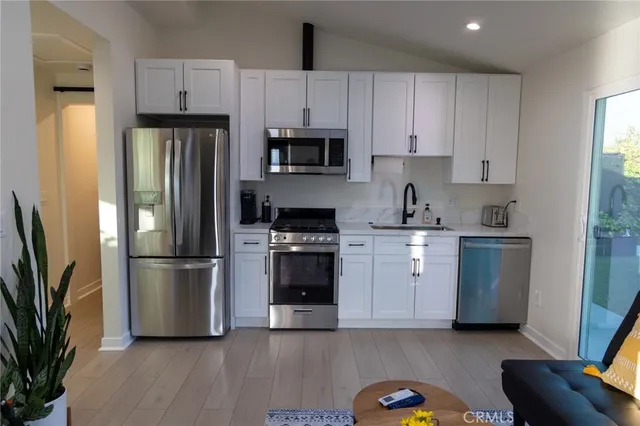 a kitchen with a refrigerator stove and white cabinets