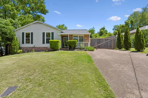 a view of a house with a yard and potted plants