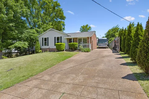 a front view of a house with a yard and potted plants