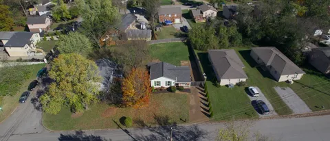 an aerial view of residential houses with outdoor space and trees
