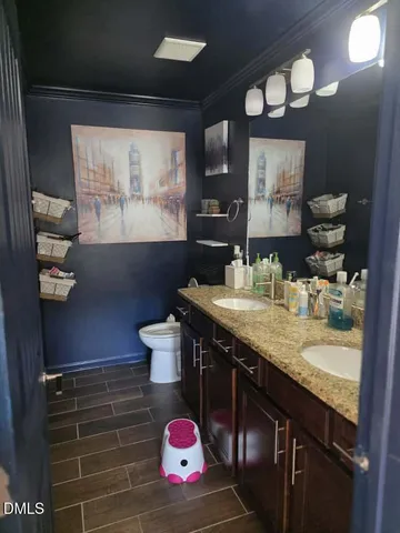 a bathroom with a granite countertop sink a toilet and a mirror