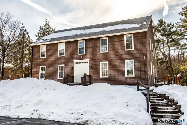 a front view of a house with a yard covered in snow