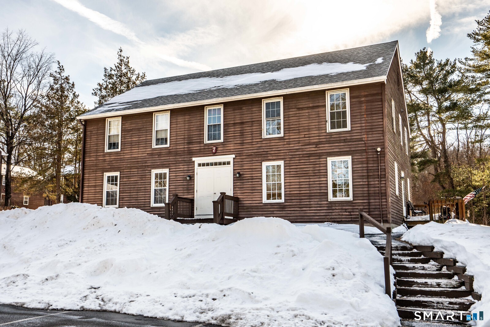 239 Old Farms Road, Unit 7C Avon, CT 06001 - Photo 1 of 17 a front view of a house with a yard covered in snow